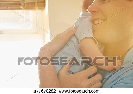 Mature man cradling baby son View Large Photo Image Stock Image - Mature man cradling baby son. Fotosearch