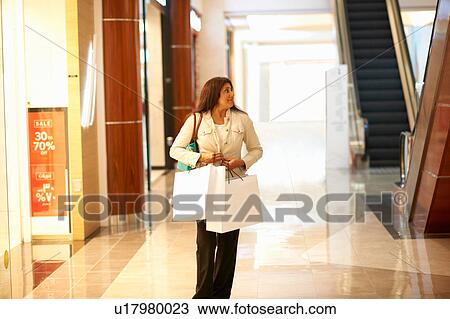 Mature woman carrying shopping bags in shopping mall, Dubai, United Arab Emirates View Large Photo Image Stock Image - Mature woman carrying shopping bags in shopping mall, Dubai, United Arab Emirates. Fotosearch