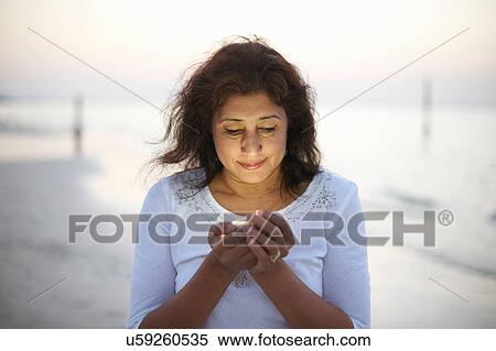 Mature woman holding light on beach at dusk, Dubai, United Arab Emirates View Large Photo Image Stock Photography - Mature woman holding light on beach at dusk, Dubai, United Arab Emirates. Fotosearch