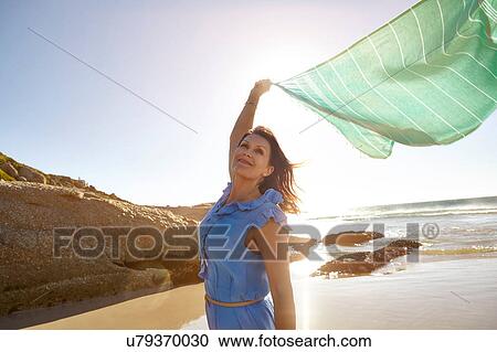 Mature woman standing on beach, holding sheer scarf in air, Cape Town, South Africa View Large Photo Image Stock Image - Mature woman standing on beach, holding sheer scarf in air, Cape Town, South Africa. Fotosearch