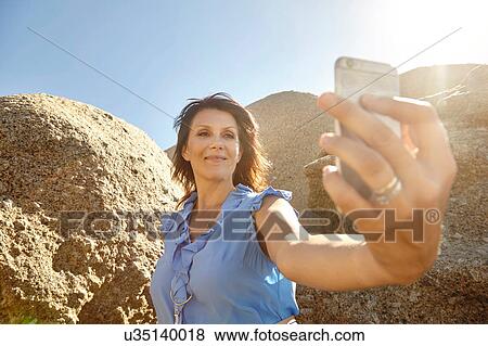 Mature woman taking selfie with smartphone View Large Photo Image Stock Photo - Mature woman taking selfie with smartphone. Fotosearch