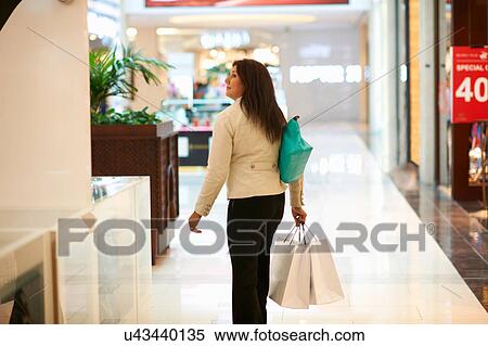 Mature woman with shopping bags in shopping mall, Dubai, United Arab Emirates View Large Photo Image Stock Photography - Mature woman with shopping bags in shopping mall, Dubai, United Arab Emirates. Fotosearch