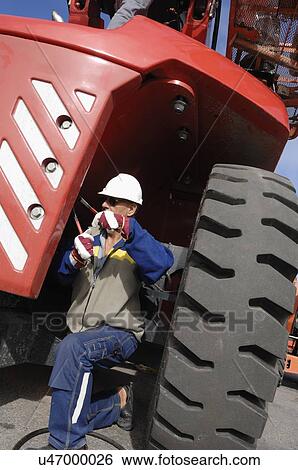Stock Photograph - Mechanic by industrial vehicle. Fotosearch