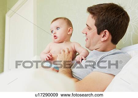 Mid adult man and baby daughter in bed View Large Photo Image Stock Photo - Mid adult man and baby daughter in bed. Fotosearch
