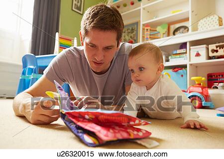 Mid adult man and baby daughter reading storybook in playroom View Large Photo Image Stock Photography - Mid adult man and baby daughter reading storybook in playroom. Fotosearch