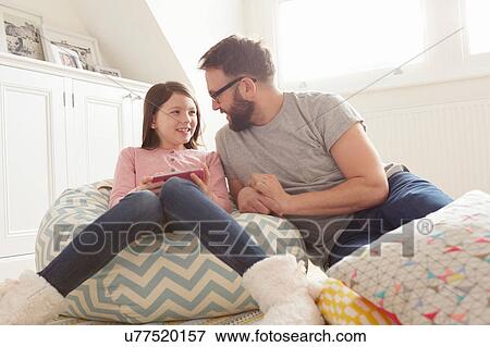 Mid adult man and daughter reclining on beanbag chair View Large Photo Image Stock Photo - Mid adult man and daughter reclining on beanbag chair. Fotosearch