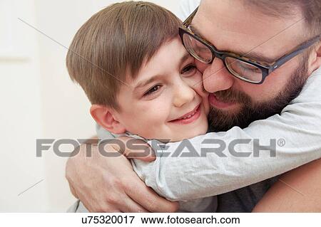 Mid adult man and son hugging each other View Large Photo Image Stock Photo - Mid adult man and son hugging each other. Fotosearch
