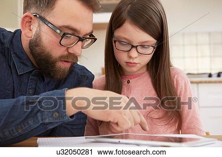 Mid adult man explaining homework to daughter at table View Large Photo Image Stock Image - Mid adult man explaining homework to daughter at table. Fotosearch