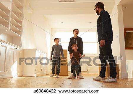 Mid adult man organising three children in new home View Large Photo Image Stock Image - Mid adult man organising three children in new home. Fotosearch