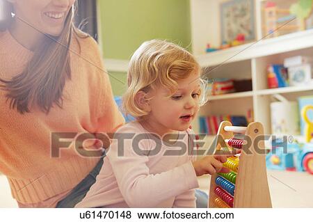 Mid adult woman and toddler daughter counting on abacus in playroom View Large Photo Image Stock Photo - Mid adult woman and toddler daughter counting on abacus in playroom. Fotosearch
