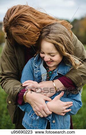 Mother and daughter hugging in meadow View Large Photo Image Stock Image - Mother and daughter hugging in meadow. Fotosearch