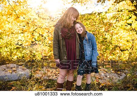 Mother and daughter smiling in wooded area View Large Photo Image Stock Image - Mother and daughter smiling in wooded area. Fotosearch