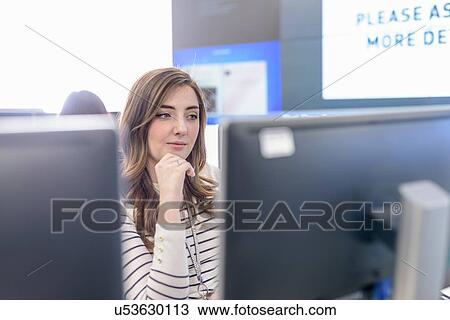 Stock Image - Office worker directing social media in call centre in car factory. Fotosearch