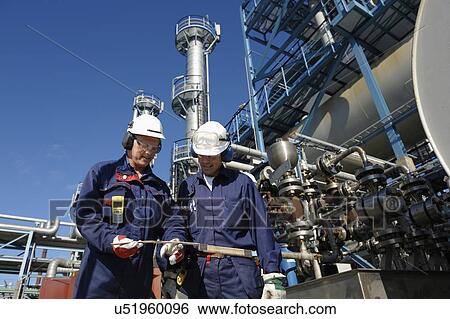Oil refinery workers and pipework View Large Photo Image Stock Photograph - Oil refinery workers and pipework. Fotosearch