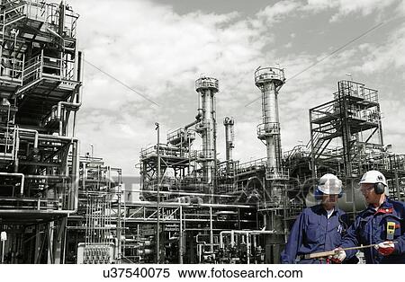 Stock Photography - Oil refinery workers and pipework. Fotosearch
