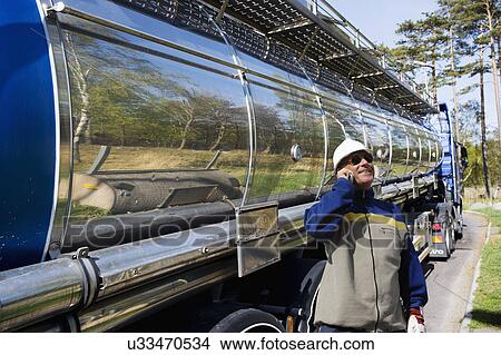 Picture - Oil tanker driver on cell phone. Fotosearch
