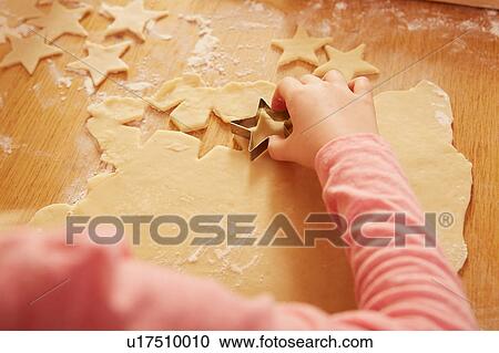 Over shoulder cropped view of girl making star shape pastry at kitchen table View Large Photo Image Stock Image - Over shoulder cropped view of girl making star shape pastry at kitchen table. Fotosearch