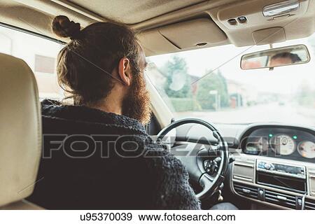 Over shoulder view of bearded man driving a car View Large Photo Image Stock Photo - Over shoulder view of bearded man driving a car. Fotosearch