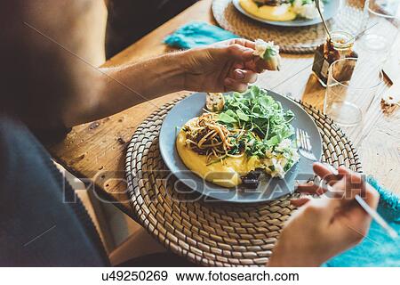 Over shoulder view of man eating omelette lunch at table View Large Photo Image Stock Photo - Over shoulder view of man eating omelette lunch at table. Fotosearch