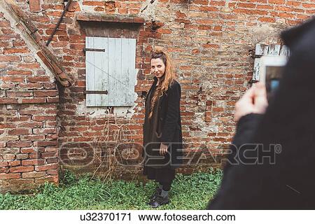 Over shoulder view of man photographing girlfriend by old brick wall View Large Photo Image Stock Image - Over shoulder view of man photographing girlfriend by old brick wall. Fotosearch