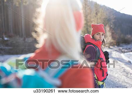 Over shoulder view of two women hiking along lakeside in Bavarian Alps View Large Photo Image Stock Image - Over shoulder view of two women hiking along lakeside in Bavarian Alps. Fotosearch