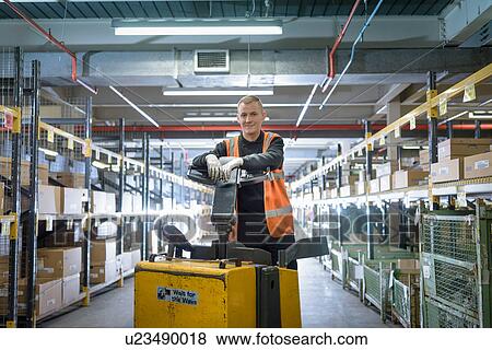 Stock Photo - Portrait of apprentice in parts store in car factory. Fotosearch