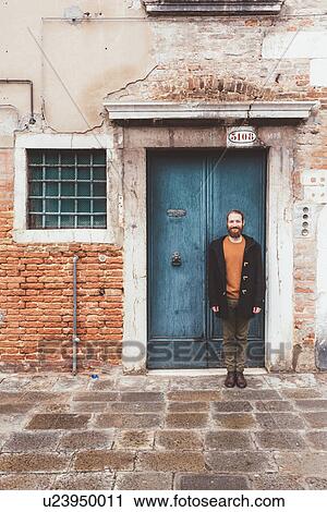 Portrait of bearded mid adult man standing in front of old doorway, Venice, Italy View Large Photo Image Stock Image - Portrait of bearded mid adult man standing in front of old doorway, Venice, Italy. Fotosearch