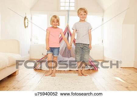 Portrait of boy and girl holding hands in front of bedroom tent View Large Photo Image Stock Image - Portrait of boy and girl holding hands in front of bedroom tent. Fotosearch