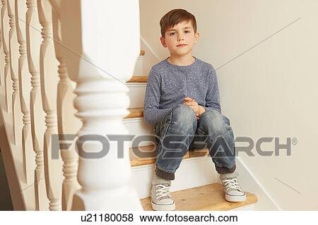 Stock Photo - Portrait of boy sitting on stairs. Fotosearch