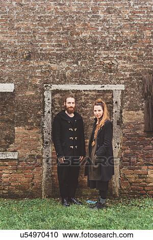 Stock Image - Portrait of couple in front of old brick wall door frame. Fotosearch