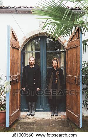 Stock Image - Portrait of couple in house doorway. Fotosearch