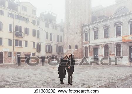 Stock Image - Portrait of couple in misty square, Venice, Italy. Fotosearch
