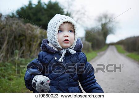 Portrait of female toddler in knit hat and gloves on rural road View Large Photo Image Stock Image - Portrait of female toddler in knit hat and gloves on rural road. Fotosearch
