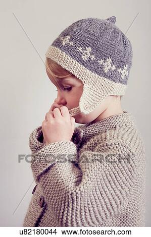 Picture - Portrait of girl fastening hand knitted hat. Fotosearch