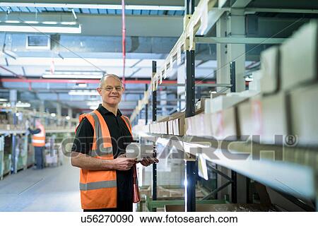 Stock Image - Portrait of manager in parts store in car factory. Fotosearch