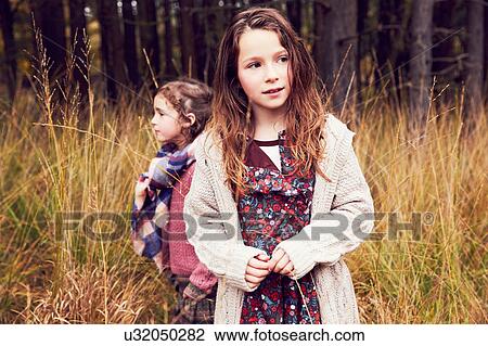 Stock Image - Portrait of two young standing in meadow. Fotosearch