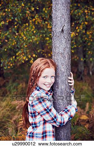 Portrait of young girl, hugging tree, smiling View Large Photo Image Stock Image - Portrait of young girl, hugging tree, smiling. Fotosearch