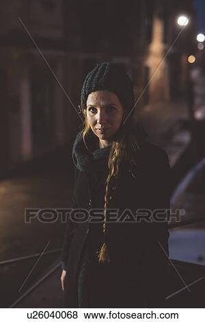 Stock Photo - Portrait of young woman in knit hat at night, Venice, Italy. Fotosearch