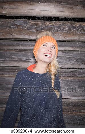 Portrait of young woman in orange knit hat looking up View Large Photo Image Picture - Portrait of young woman in orange knit hat looking up. Fotosearch