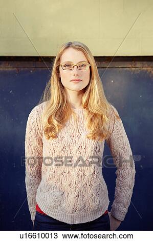 Stock Image - Portrait of young woman outdoors, long blonde hair and glasses. Fotosearch