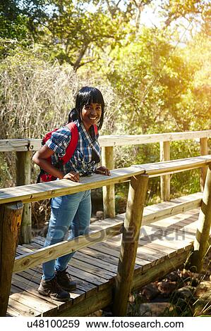Stock Photo - Portrait of young woman standing on bridge, Cape Town, South Africa. Fotosearch