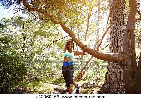 Stock Photograph - Portrait of young woman wearing sports clothing, in rural setting. Fotosearch