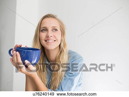 Portrait of young woman with long blond hair holding coffee cup View Large Photo Image Stock Photo - Portrait of young woman with long blond hair holding coffee cup. Fotosearch