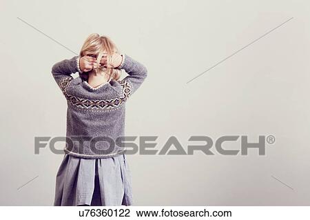 Stock Image - Rear view of girl fidgeting with blond hair. Fotosearch