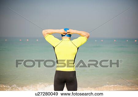 Rear view of mature man adjusting swimming cap on beach, Dubai, United Arab Emirates View Large Photo Image Stock Photo - Rear view of mature man adjusting swimming cap on beach, Dubai, United Arab Emirates. Fotosearch