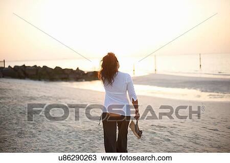 Rear view of woman strolling on beach, Dubai, United Arab Emirates View Large Photo Image Stock Image - Rear view of woman strolling on beach, Dubai, United Arab Emirates. Fotosearch