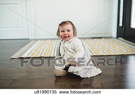 Rosy-cheeked baby sitting on the floor smiling View Large Photo Image Stock Photography - Rosy-cheeked baby sitting on the floor smiling. Fotosearch