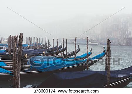 Picture - Rows of gondolas on misty canal, Venice, Italy. Fotosearch