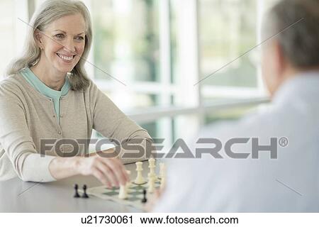 Stock Image - Senior couple playing chess. Fotosearch