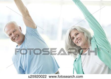 Senior couple stretching arms upwards View Large Photo Image Stock Image - Senior couple stretching arms upwards. Fotosearch
